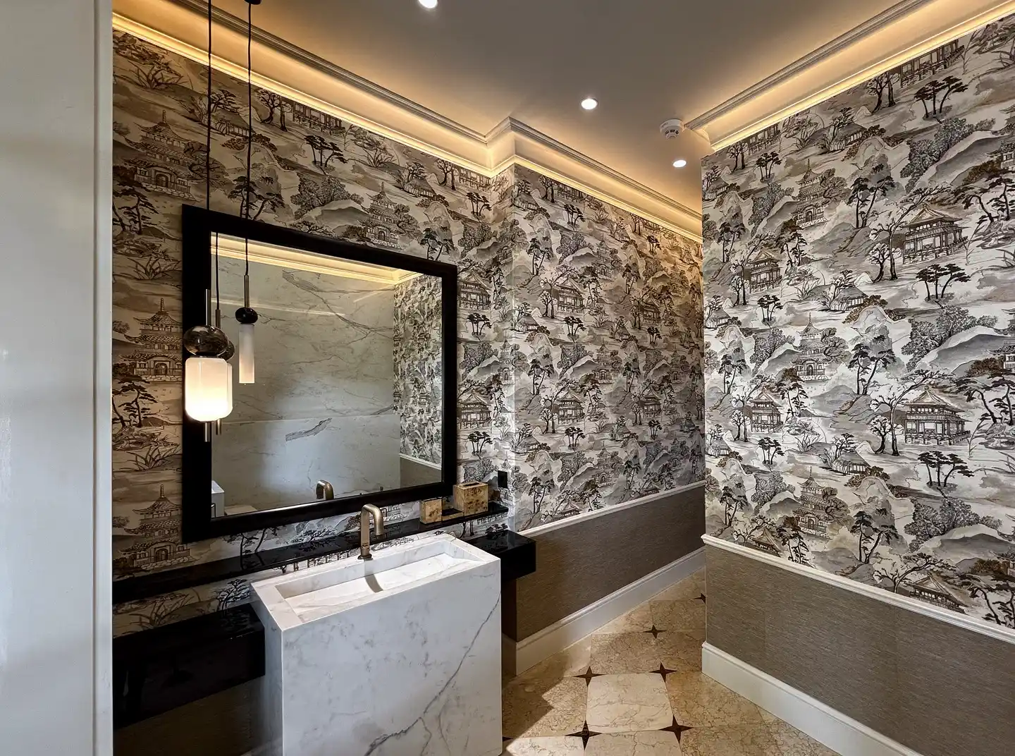 Vanity with black mirror against patterned wallpaper